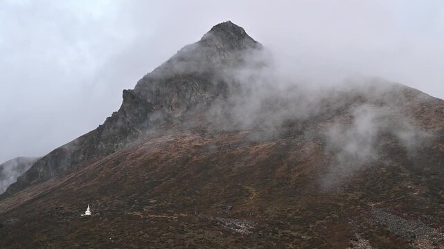Fog covered Kyanjin Ri peak (4,773 m) in Langtang valley, Nepal. The Langtang Valley is mainly inhabited by the Tamang people they mainly follow Tibetan Buddhism.