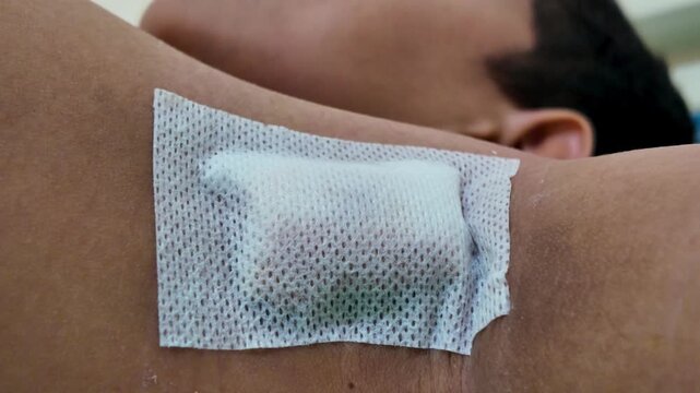 Close-up view of a medical gauze bandage on a patient's underarm