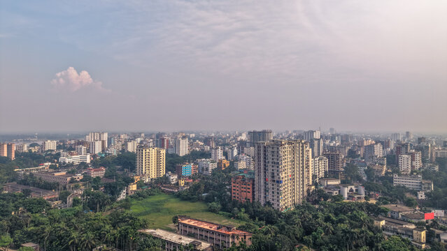 Aerial view of a densely populated urban landscape in dhaka, bangladesh, featuring highrise residential buildings surrounded by lush green trees