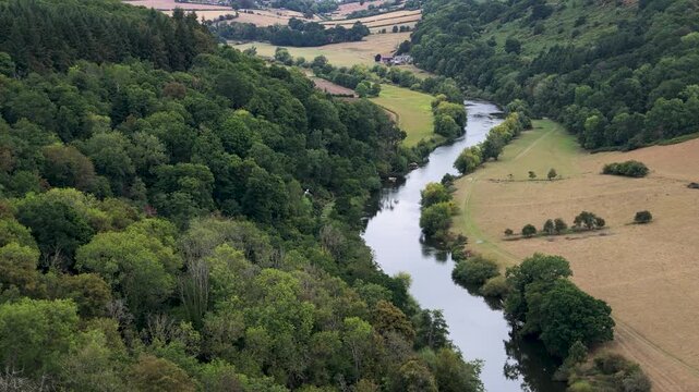River Wye winds between dense woodland and open fields as the camera slowly pans across the rural landscape.