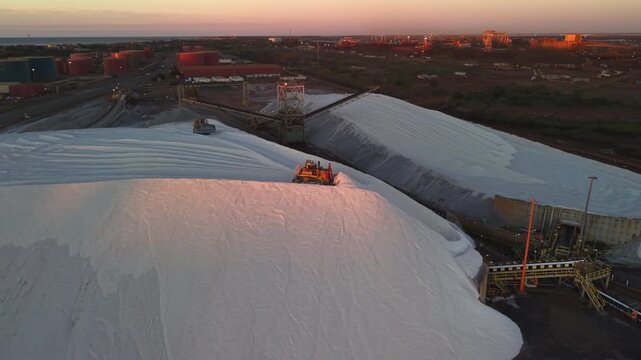 Excavators load raw material onto conveyors for shipping port hedland australia at golden hour