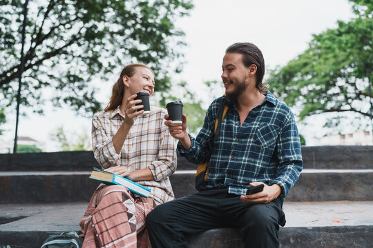 Happy students sharing coffee outdoors on campus