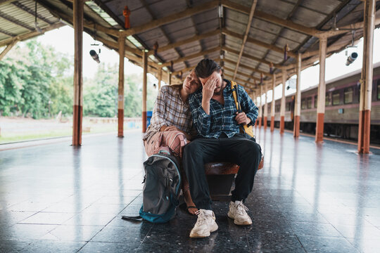 Exhausted couple feeling disappointment at old train station