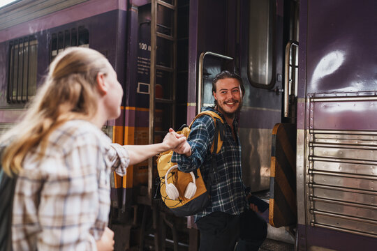 Couple traveling together boarding train at station