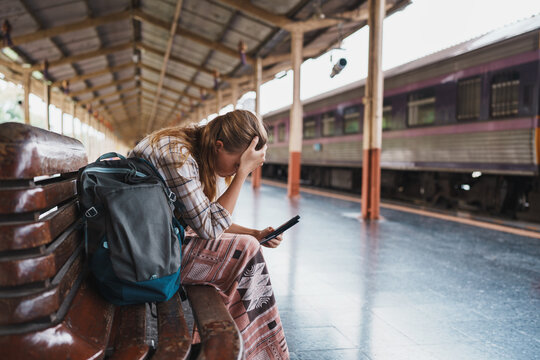 Woman feeling stressed at train station missing travel