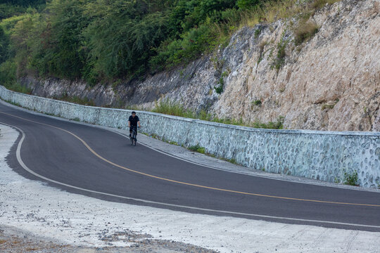 Cyclist Riding on a Scenic Mountain Road