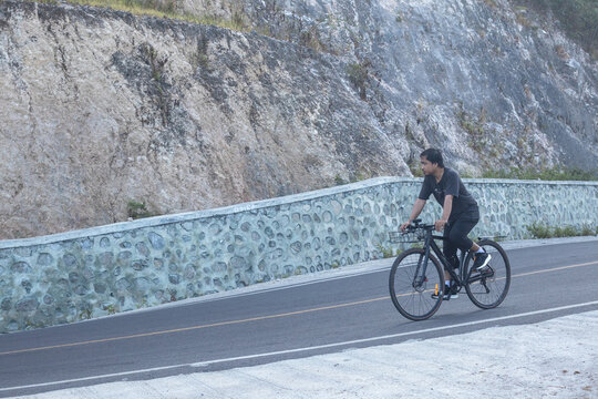 Young Man Cycling on a Mountain Road