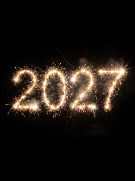 Vertical front view of dazzling 2027 fireworks exploding in darkness
