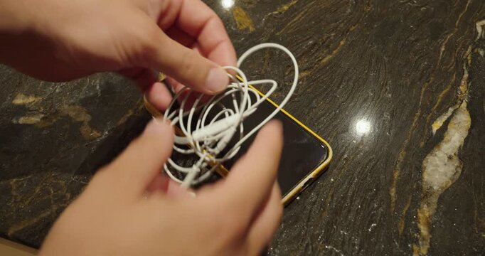 Tangled Earphones on Smartphone &ndash; Cable Mess and Technology Problem Concept