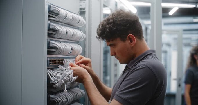 Network Engineer Patches Ethernet Connections, Female Colleague Services Another Cabinet, Showing Collaborative Infrastructure Maintenance, Cable Management and Coordinated Data Center Operations.