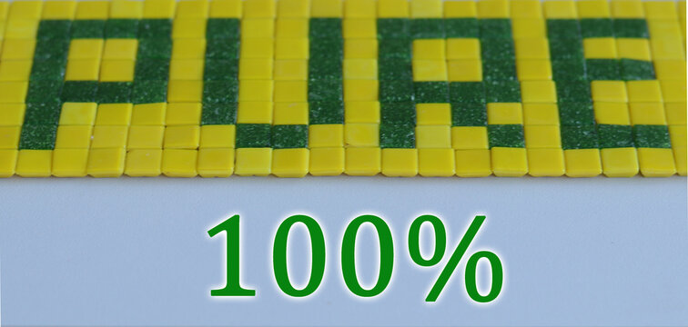 Ceramic tile in the form of the word peace. Green grass background. Diet concept with green and yellow square tiles on blue background. NATURAL word