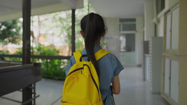 Asian girl student walking down school hallway