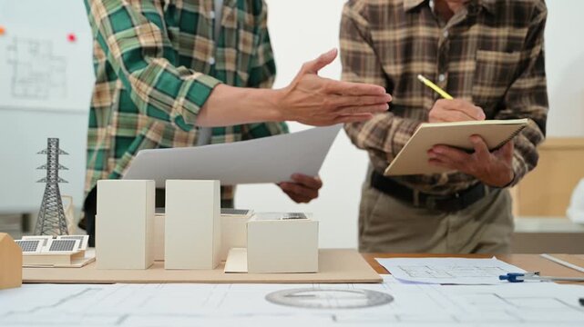 Creative architect projecting on the big drawings with architectural project at construction site at desk in  office