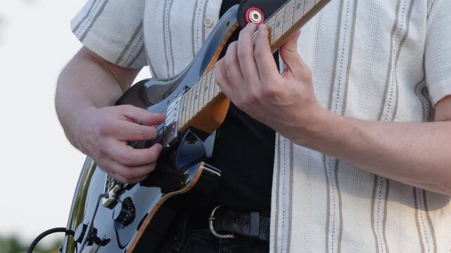 Music performance detail: Close-up guitarist playing electric guitar
