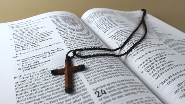 Open holy Bible with wooden cross necklace laid across the pages, focus on scripture text conveying faith, prayer, devotion, and the central role of Gods word in Christianity