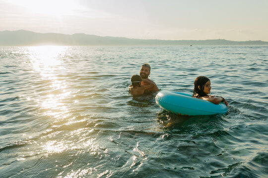Father and Children Swimming at Sunset in the Strait of Messina, Calabria, Italy