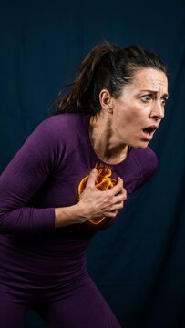 Woman experiencing sudden chest pain with a glowing heart illustration. Medical visualization of a heart attack or cardiovascular emergency concept for health awareness