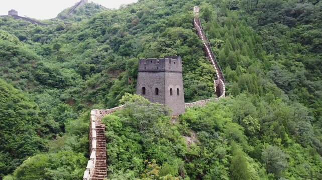 Huangyaguan Great Wall ancient stone watchtower and winding fortification through lush green mountain forest, aerial drone view