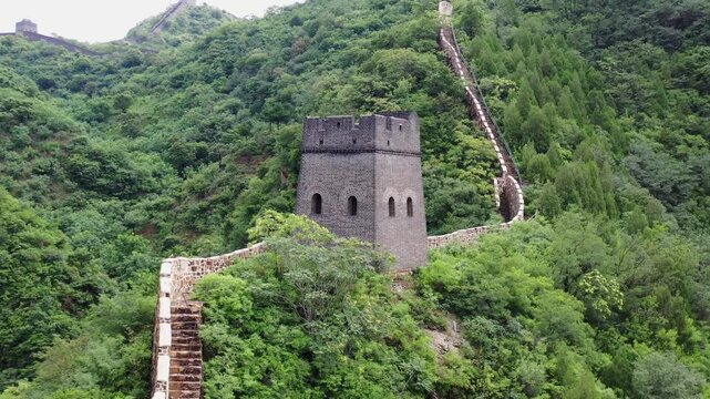 Huangyaguan Great Wall ancient stone watchtower and rampart winding through lush green mountain forest in China