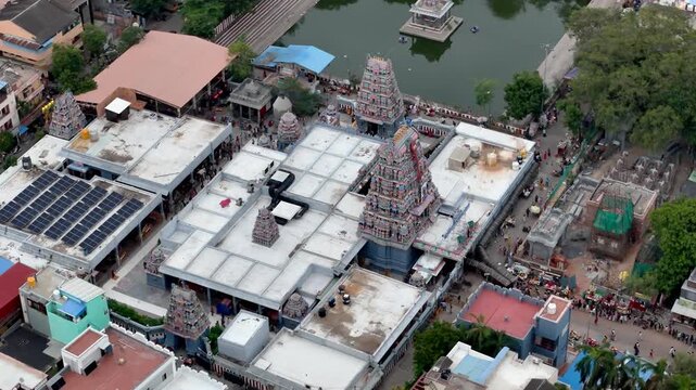Cinematic top-down aerial drone view of Vadapalani, Chennai, showcasing the Vadapalani Murugan Temple and its rectangular temple tank surrounded by a densely packed urban neighborhood.