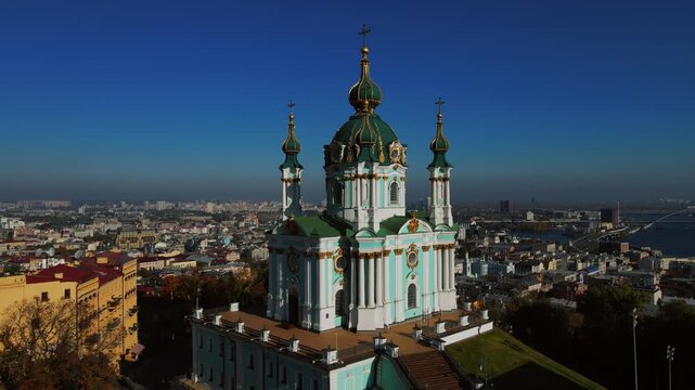 Aerial flyby around Saint Andrew Church overlooking Kyiv city skyline