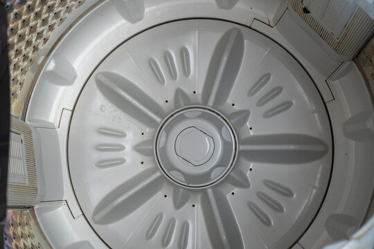 Top down view inside the empty drum and pulsator of a washing machine.