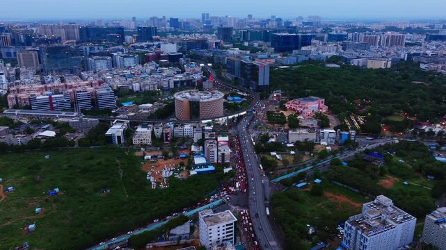 Aerial wide view of hitec city silicon valley with illuminated Shilpakala Vedika, Shilparamam and cyber towers at hyderabad, telangana, india. sun set time, arc shot, drone shot, 4k.