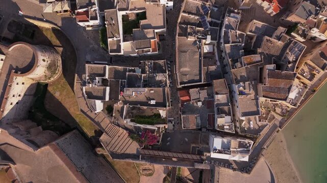 Drone zenithal view flying over the dense historical architecture and narrow streets of Otranto old town in Italy.