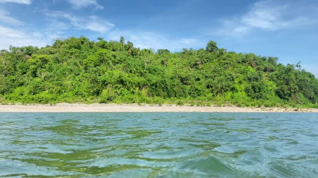 Beautiful forested island with tranquil river water beneath blue sky