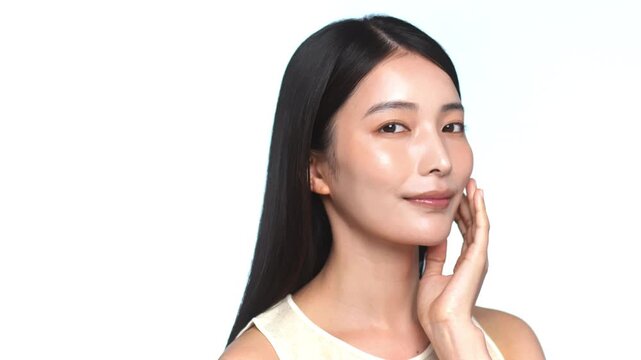 頬に手を当てて肌のケアをする若い日本人女性のビューティーカット（白背景）