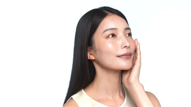 頬に手を当てて肌のケアをする若い日本人女性のビューティーカット（白背景）