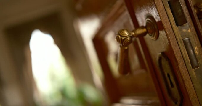 Antique brass door handle close-up, cinematic 360-degree rotating shot, ornate vintage hardware, warm golden lighting.