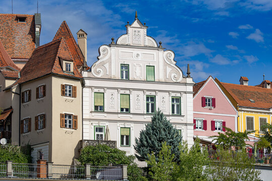 Historic step-gabled building and colorful traditional townhouses along the waterfront in Frohnleiten, Styria, Austria