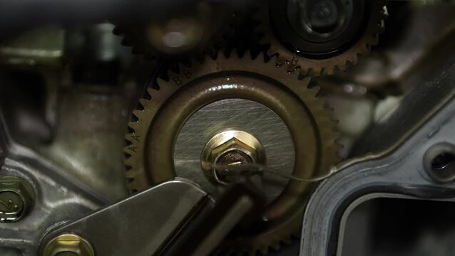 A macro close-up view highlights timing gears with teeth and alignment marks inside an opened automotive internal combustion engine block.