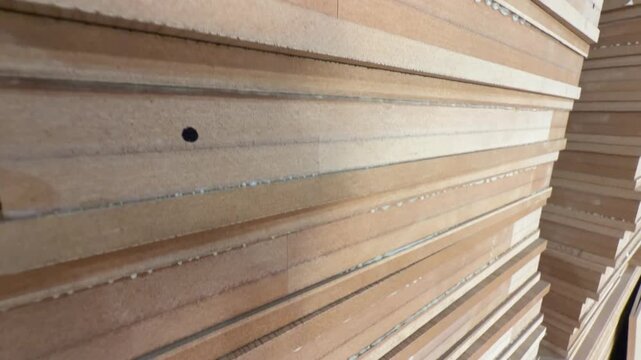 Stacked MDF panels with visible seams, medium density fiberboard sheets in warehouse