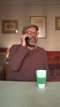 Handsome man talking on a phone at home