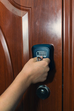 Hand entering code on digital keypad lock mounted on a wooden door, showcasing security features and modern locking technology in a residential setting