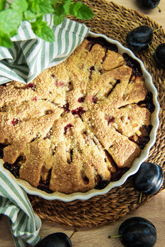 Baked plum dessert with crumb topping on rustic table