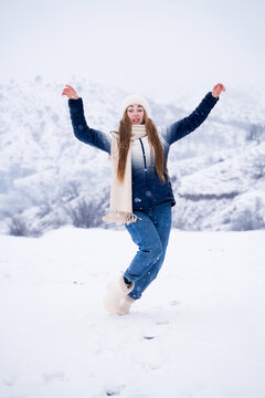A woman slips and falls on snowy ground in winter. It's a humorous accident that happened during an outdoor activity. The safety in winter season and active lifestyle concepts .