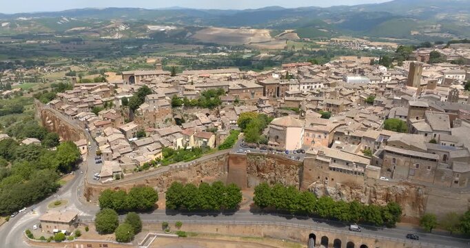 Aerial view of the edge of the town of Orvieto, in the province of Terni, in Umbria, Central Italy, with the road running below the vertical cliff of volcanic tuff and the hills of the countryside.