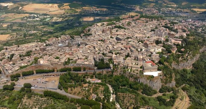 High angle view of the town of Orvieto, in the province of Terni, in Umbria, Central Italy, built on a plateau of volcanic tuff and surrounded by farmland, trees and the hills of the countryside.