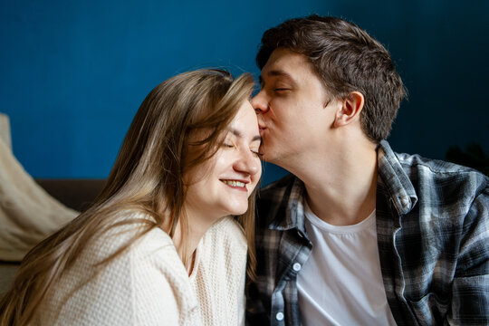 Young couple share a tender kiss at home