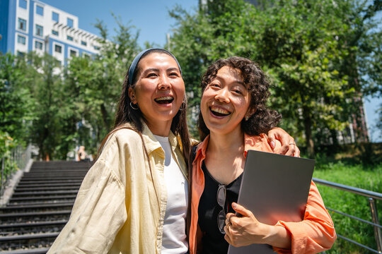 Happy students embrace outdoors on a university campus