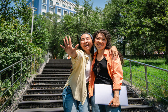 Happy students embrace outdoors near campus stairway