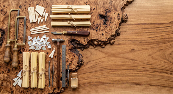 Hyper-realistic top down view of Moroccan wood marquetry tools on Thuya burl