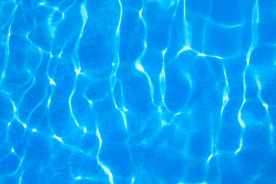 Sunlight ripple pattern on clear blue swimming pool water