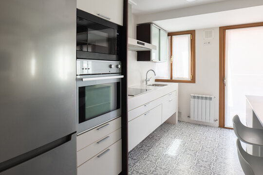 Modern apartment kitchen with built-in appliance and tile floor