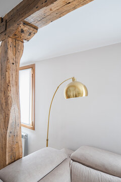 Modern apartment interior with rustic beam and gold floor lamp