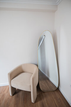 Modern apartment interior with armchair and floor mirror