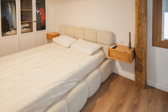 Modern apartment bedroom with bed and wooden furniture